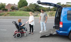 Photo d'un enfant en fauteuil s'apprêtant à entrer dans un véhicule.